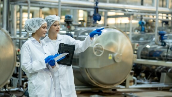 Two food scientist are doing a quality check at the manufacturing unit.