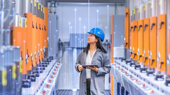 Engineer inspecting electrical control panels in a smart industrial facility.